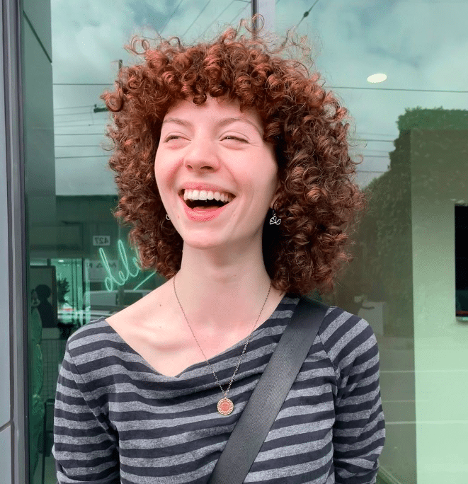 smiling happy female customer outside hair studio